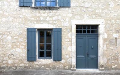 stone built french house with grey window shutters