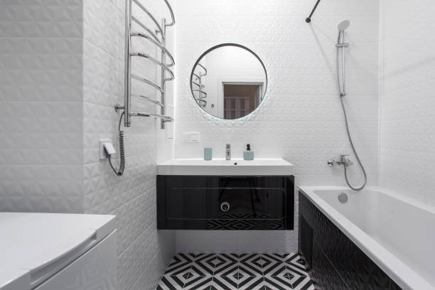a modern bathroom with a black vanity, mirror, and hardware