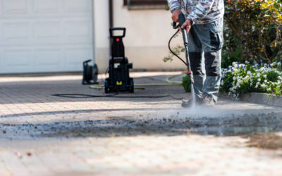 senior man at home cleaning the yard with high pressure washer