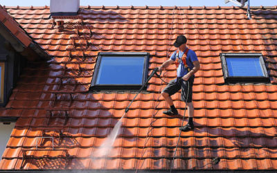 worker is cleaning the roof and rainwater gutter with high pressure.